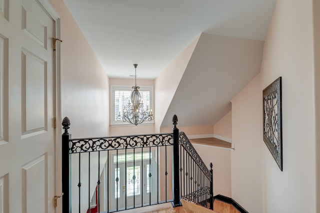 staircase with hardwood / wood-style flooring and an inviting chandelier