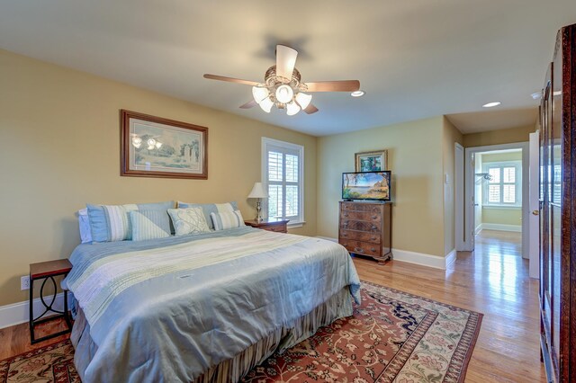 bedroom with light hardwood / wood-style flooring, multiple windows, and ceiling fan