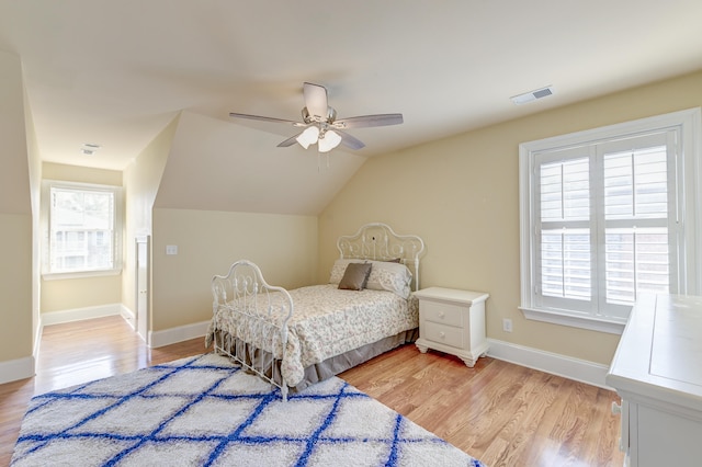 bedroom featuring ceiling fan, light hardwood / wood-style floors, and vaulted ceiling