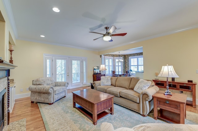 living room featuring light hardwood / wood-style flooring, a wealth of natural light, and crown molding