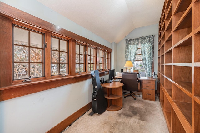 carpeted office space featuring lofted ceiling, a textured ceiling, and baseboards