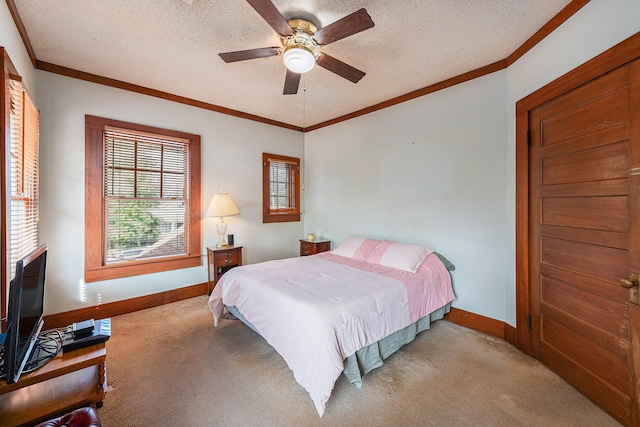 carpeted bedroom featuring baseboards, ornamental molding, ceiling fan, and a textured ceiling