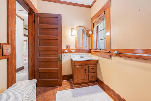 bathroom featuring ornamental molding, vanity, baseboards, and tile patterned floors