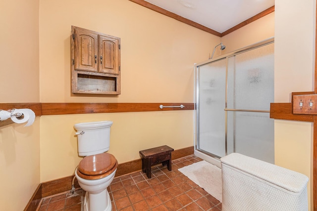 bathroom with ornamental molding, baseboards, a shower stall, and toilet