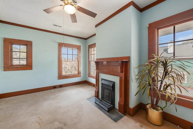 carpeted living area with visible vents, ornamental molding, ceiling fan, a textured ceiling, and baseboards