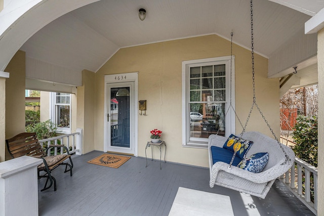 entrance to property featuring covered porch and stucco siding