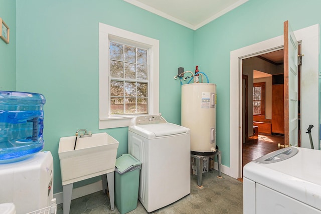 laundry area with crown molding, electric water heater, a sink, laundry area, and baseboards