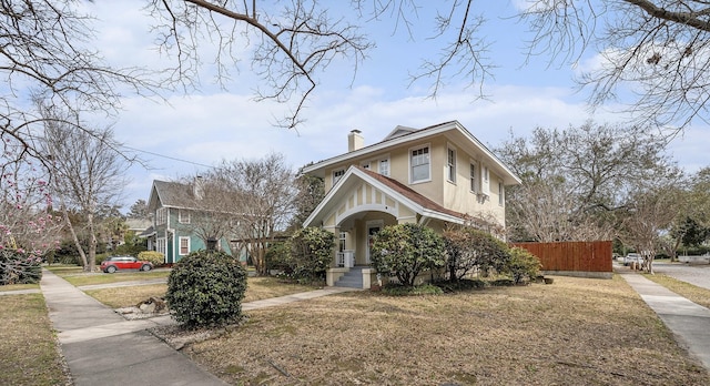 view of front of property with fence, a chimney, and stucco siding