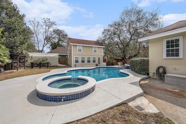 view of swimming pool with a pool with connected hot tub, a patio, and fence