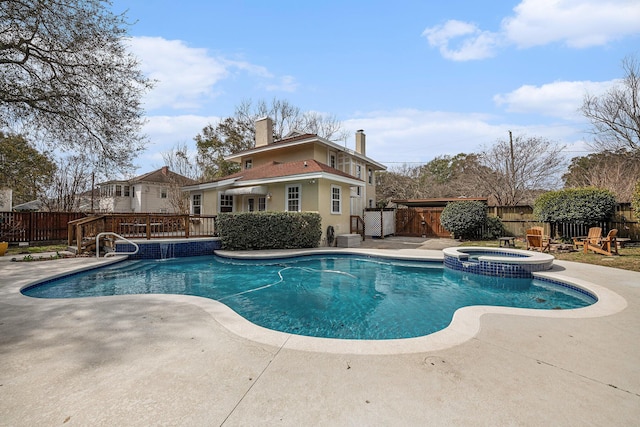 view of swimming pool featuring a fenced backyard, a pool with connected hot tub, and a patio