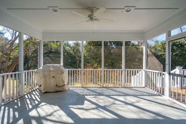 unfurnished sunroom with ceiling fan