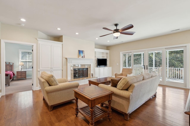 living room featuring a ceiling fan, wood finished floors, a high end fireplace, and recessed lighting