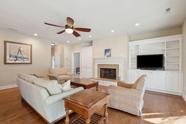 living room with recessed lighting, visible vents, a fireplace, and wood finished floors