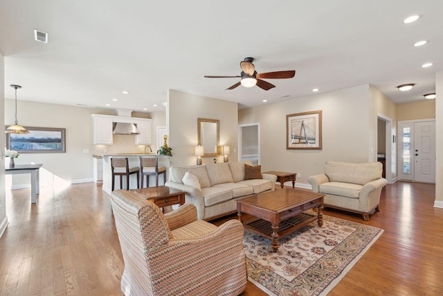 living room featuring recessed lighting, visible vents, light wood-style flooring, a ceiling fan, and baseboards