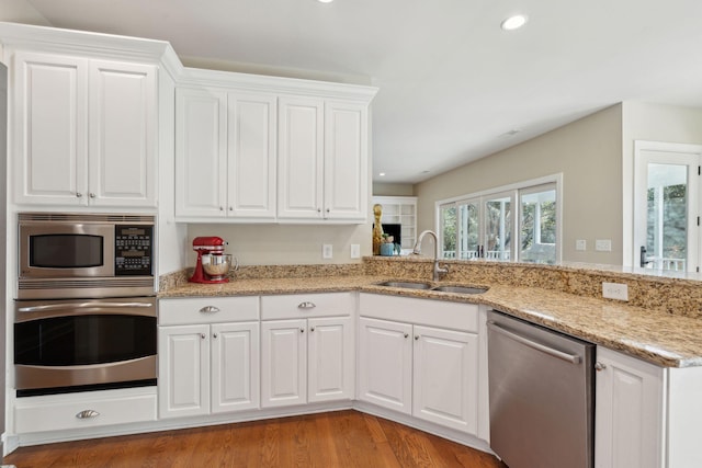 kitchen with appliances with stainless steel finishes, a sink, and white cabinets