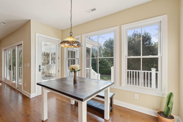 dining space with dark wood-style floors, plenty of natural light, and visible vents