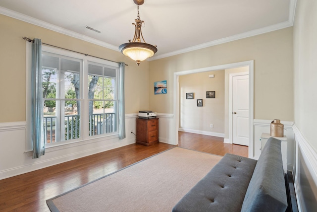 living area featuring ornamental molding, wood finished floors, visible vents, and baseboards