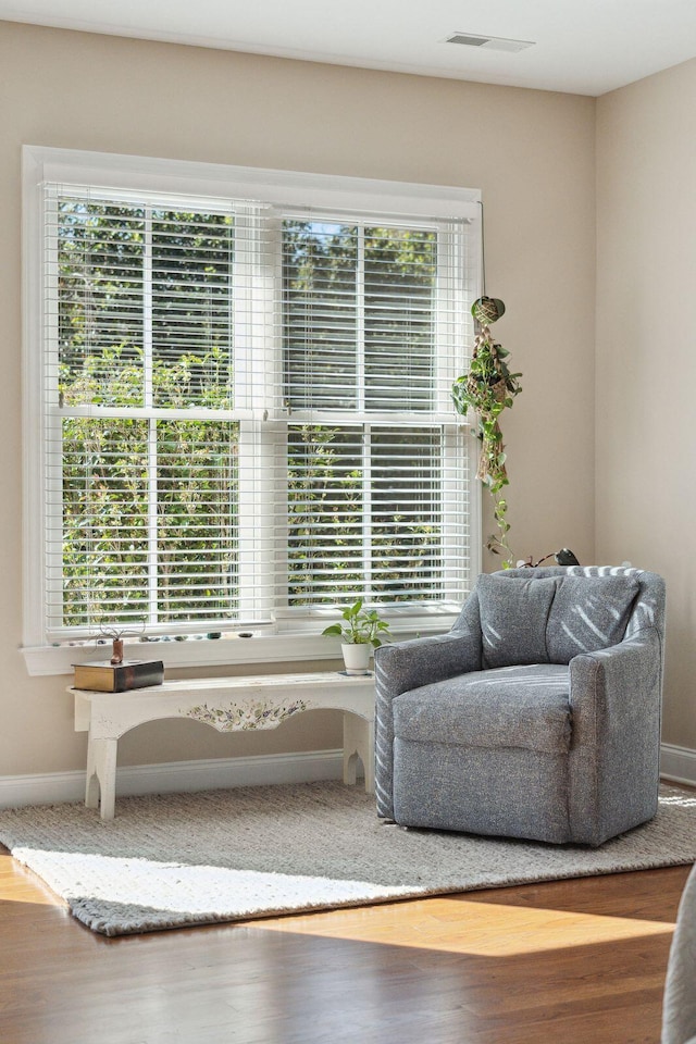 sitting room featuring a wealth of natural light, wood finished floors, and visible vents