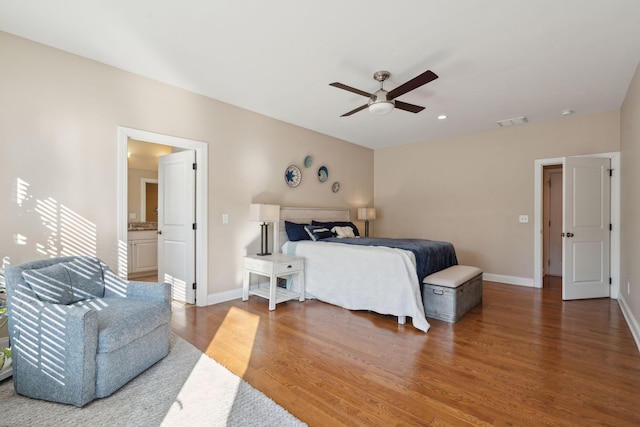 bedroom featuring a ceiling fan, wood finished floors, visible vents, and baseboards