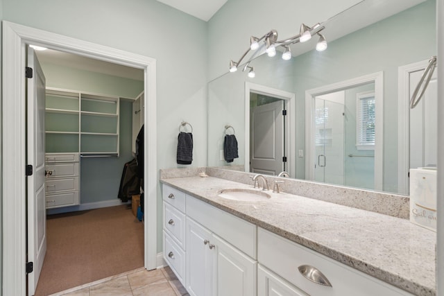 full bath with tile patterned flooring, a shower stall, and vanity