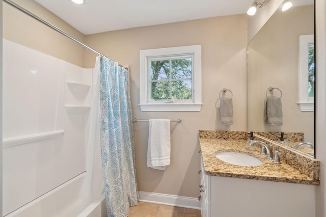 full bathroom featuring tile patterned flooring, shower / bath combo with shower curtain, vanity, and baseboards