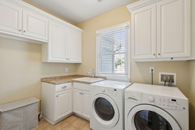 laundry room featuring washer and dryer, cabinet space, a sink, and light tile patterned flooring