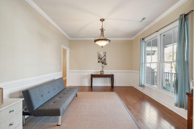 sitting room featuring ornamental molding, baseboards, and wood finished floors