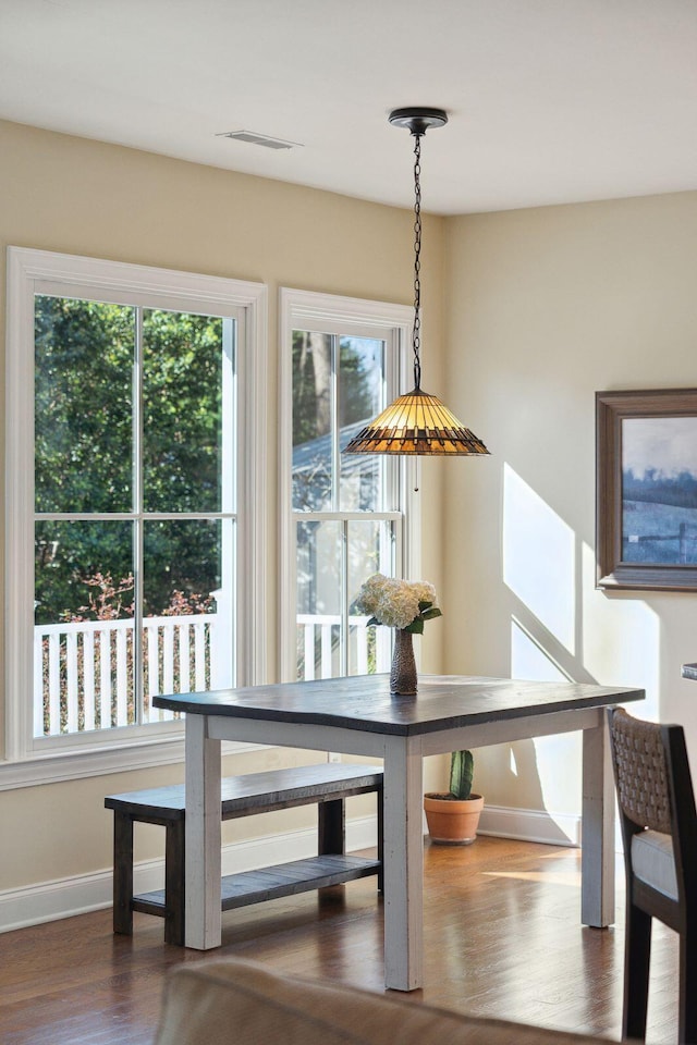 dining area with dark wood-style flooring, visible vents, and baseboards