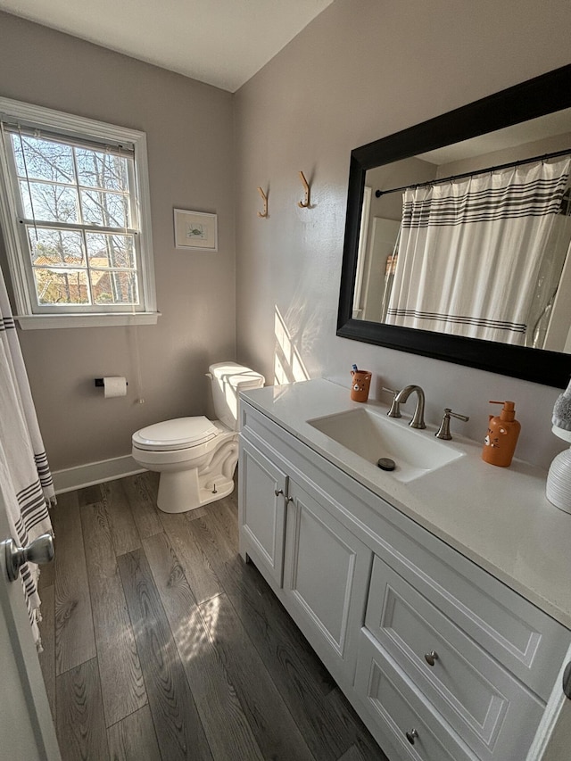 full bathroom with toilet, vanity, wood finished floors, a shower with curtain, and baseboards