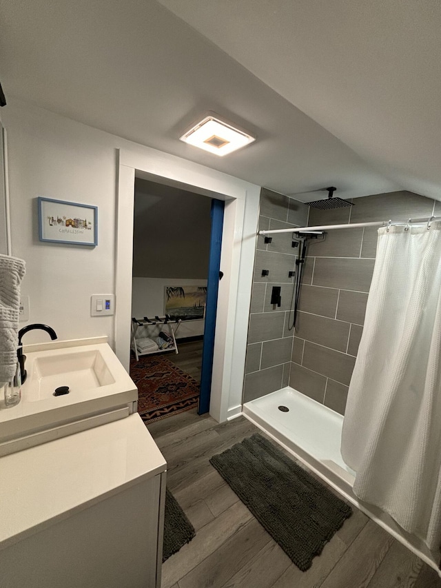 full bath with a shower stall, wood finished floors, and vanity