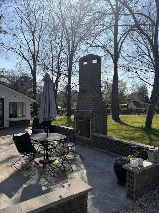 view of patio / terrace with an outdoor brick fireplace and outdoor dining space