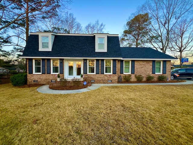 view of front of home featuring crawl space, roof with shingles, a front yard, and brick siding