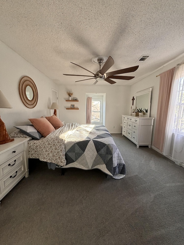 unfurnished bedroom featuring carpet floors, multiple windows, visible vents, and a ceiling fan