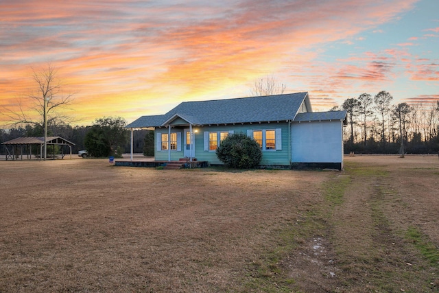 view of front of home with a carport and a lawn