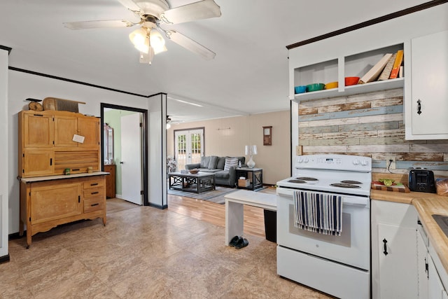 kitchen with white cabinetry, wood walls, ceiling fan, and white range with electric cooktop