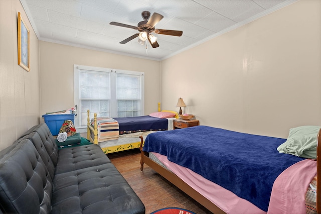 bedroom with ornamental molding, hardwood / wood-style floors, and ceiling fan