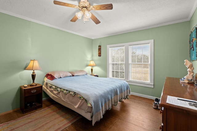 bedroom featuring wood-type flooring, ornamental molding, a textured ceiling, and ceiling fan