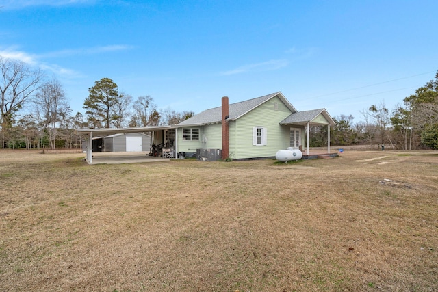 rear view of property featuring a carport and a lawn