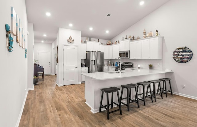 kitchen featuring light countertops, appliances with stainless steel finishes, a peninsula, and white cabinetry