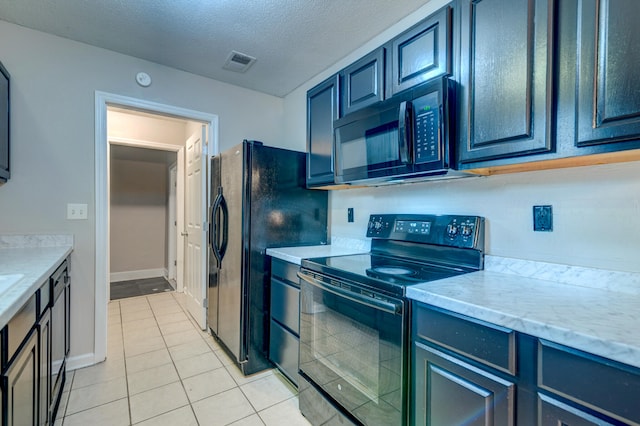 kitchen featuring black appliances, a textured ceiling, and light tile patterned flooring