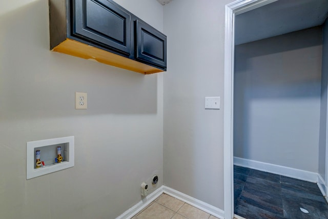 laundry area featuring electric dryer hookup, hookup for a washing machine, cabinets, and tile patterned floors