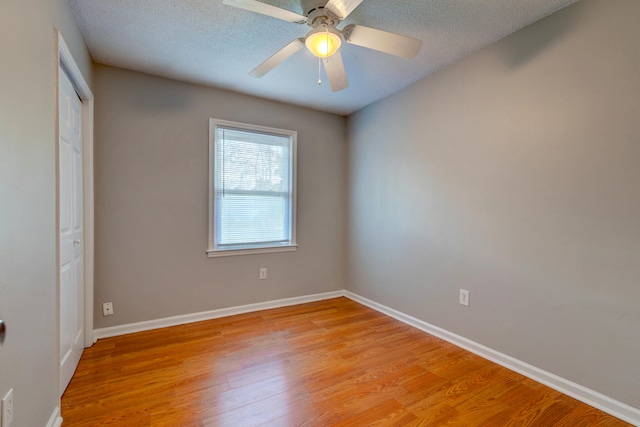 unfurnished bedroom featuring light hardwood / wood-style floors, ceiling fan, and a textured ceiling