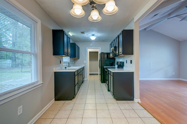 kitchen with light hardwood / wood-style floors, black appliances, a textured ceiling, an inviting chandelier, and lofted ceiling with beams