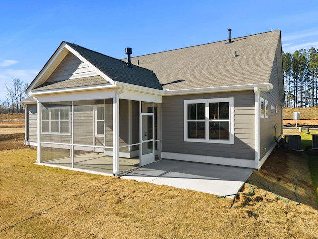 rear view of house with central air condition unit, a sunroom, a yard, and a patio