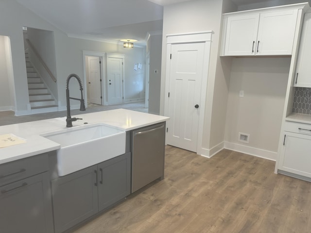 kitchen featuring dishwasher, sink, white cabinetry, and hardwood / wood-style floors