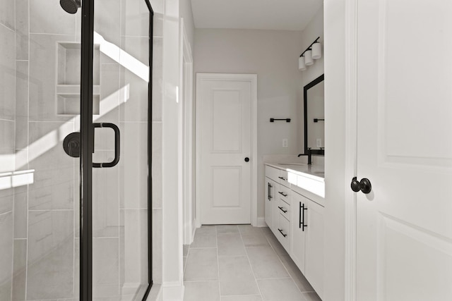 bathroom featuring a shower with shower door, vanity, and tile patterned flooring