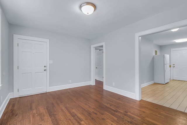 unfurnished room featuring wood finished floors and baseboards