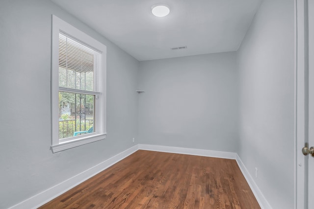 unfurnished room with dark wood finished floors and baseboards