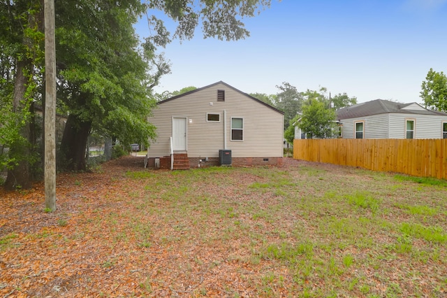 back of property with entry steps, fence, crawl space, and central AC unit