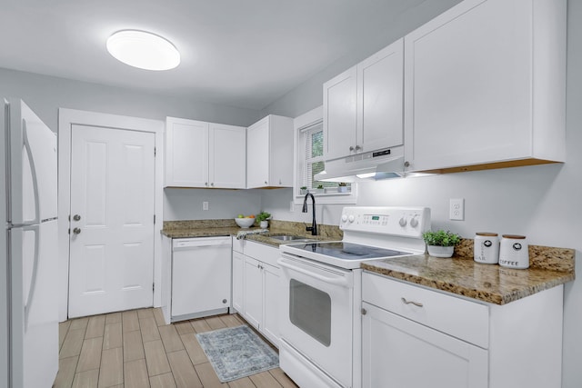 kitchen with white appliances, a sink, white cabinetry, stone counters, and under cabinet range hood